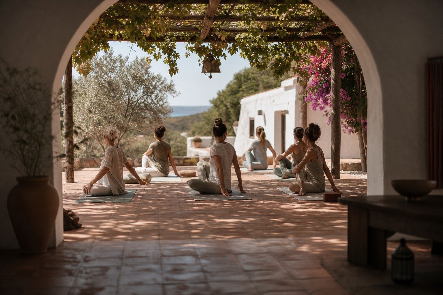 Grupo practicando torsiones en un patio con pérgola